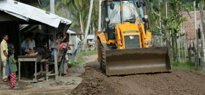 Sapek village where the road is being rebuilt and an Oxfam funded JCB does the work. Lamno, Aceh Province, Sumatra, Indonesia