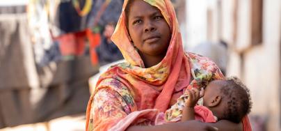 Shaima Ali, a refugee from Sudan in Renk, South Sudan speaks on her experience relocating after being displaced from the conflict in Sudan while holding her baby Fahima during feeding time.
