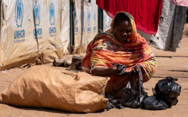 Shaima Ali, a refugee from Sudan selling charcoal outside her home in Renk, South Sudan. 