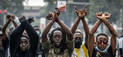 Manifestantes hacen gestos con los brazos delante de agentes de policía de Kenia durante una protesta contra las subidas de impuestos en el centro de Nairobi, mientras en el Parlamento los diputados debaten el Proyecto de Ley de Finanzas de 2024, el 18 de junio de 2024.