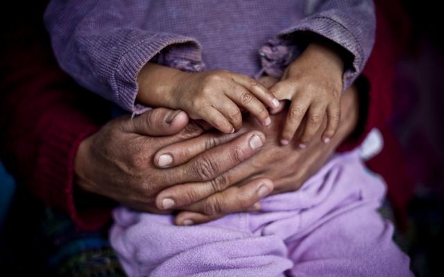 Arms encircling small child 