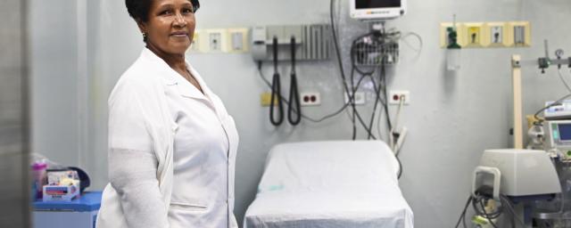 Care giver stands in front of hospital equipment 