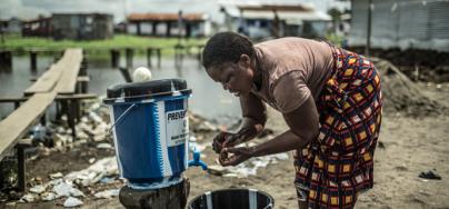 A woman is washing her hands, to prevent Ebola's spread, in Clara Town, Liberia. Photo: Pablo Tosco/Oxfam