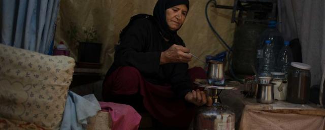 Imm prepares coffee in the makeshift kitchen of her tent. On the outskirts of 111, a village nestled into the north of the Beqaa valley, eastern Lebanon, 30KM away from the Syrian borders. Credit: Adrian Hartrick/Oxfam
