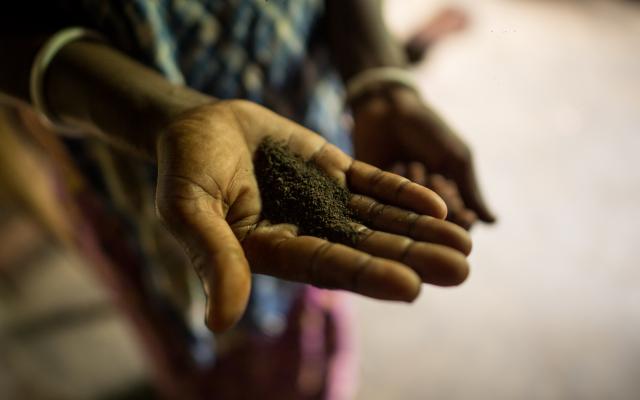 Una mujer muestra la porción de té que las y los trabajadores reciben mensualmente. Photo: Roanna Rahman/Oxfam