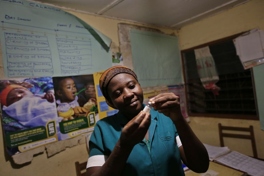 Latana Ganda, infirmière à la clinique de Kpatua inspecte un vaccin qu'elle conserve dans le réfrigérateur alimenté à l'énergie solaire. 