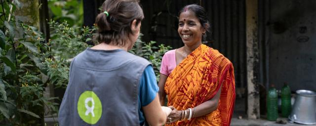 Ashima Biswas is a scarf weaver in Phulia village, Kolkata. She is pictured with an Oxfam Intermón worker.
