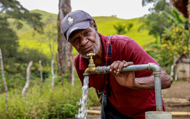  Esoi of Nogorunte community in Papua New Guinea (PNG), drinks water from a newly built tap outside his home
