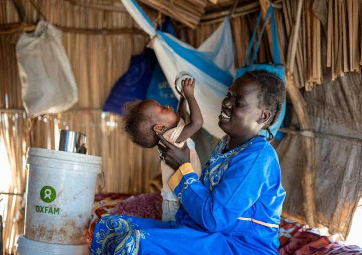 Ayul Ajak, a visually impaired mother of six plays with her child at her home in her makeshift home in Renk, South Sudan after she fled her home in Sudan.