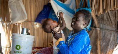 Ayul Ajak, a visually impaired mother of six plays with her child at her home in her makeshift home in Renk, South Sudan after she fled her home in Sudan.