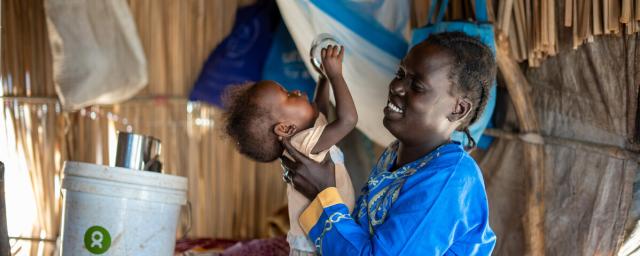 Ayul Ajak, a visually impaired mother of six plays with her child at her home in her makeshift home in Renk, South Sudan after she fled her home in Sudan.
