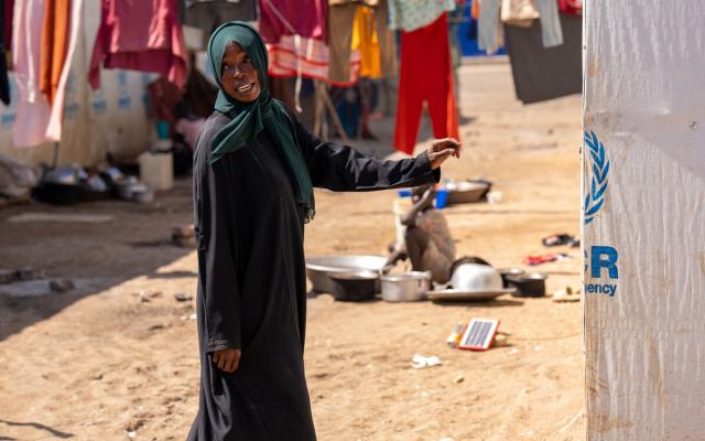 Nadia Zahad, a refugee from the Sudan war stands outside her makeshift home in Renk, South Sudan. 