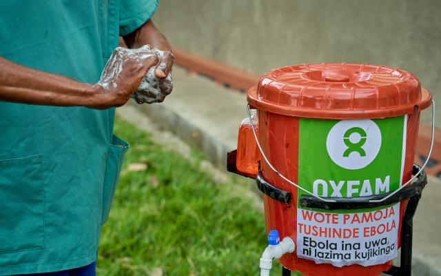Emmanuel Bahiga setting up bucket with tap.  Supervision of hygiene measures at the Rwampara General Referral Hospital.