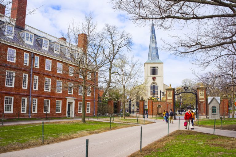 First Parish Church in Harvard Square and tourists in Harvard Yard in the campus of Harvard University, Massachusetts, MA, USA. The church is built 400 years ago. — Photo by erix2005