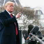 President Donald Trump speaking to members of the press with many microphones in front of him, pointing and fielding questions — Photo by Tennessee